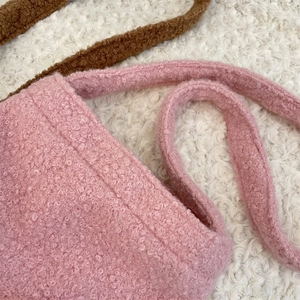 Gros plan du sac seau en polaire rose avec texture douce et détails de couture soignés