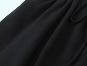 Detail view of black knit camisole fabric with woven drawstring and textured texture
