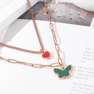 Close-up of double-layer rose gold necklace with red heart and green butterfly pendants