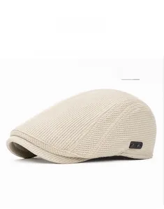 Vue détaillée du tissu en maille gaufrée beige de la casquette avec étiquette noire