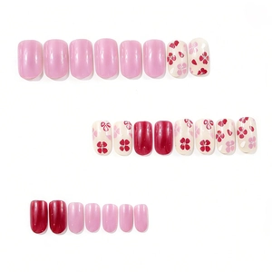 Short square press-on nails with wine red and floral designs on a white background