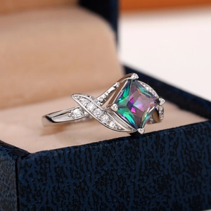 Macro shot of a silver ring with square rainbow zircon in a velvet jewelry gift box