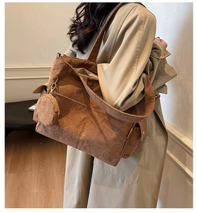 Detailed texture of brown corduroy tote bag with small matching round pendant charm