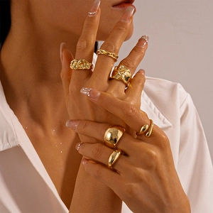 Minimalist gold metallic wrinkled teardrop rings set for women displayed on model hand