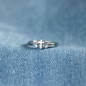 S925 sterling silver cross ring with zircon stones on denim fabric background
