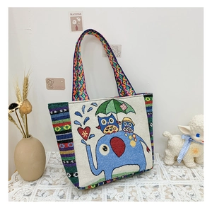 Detailed shot of ethnic canvas tote bag with colorful woven strap and elephant patterns