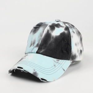 Distressed tie-dye baseball cap in blue and black graffiti style from a 45-degree angle view