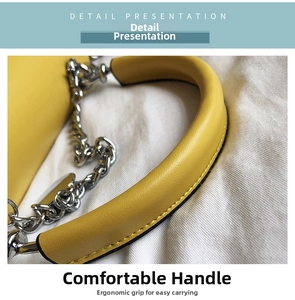 Detail of yellow leather handbag with silver chain strap and thick ergonomic handle