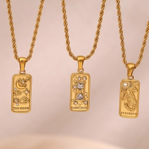 Macro view of three gold-plated tarot necklaces featuring Moon, Sandglass, and Leopard pendants