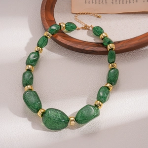 Detail of dark green acrylic beads with gold spacers and lobster clasp on retro necklace