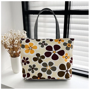 Detailed close-up of floral print canvas tote bag with gray webbing handles