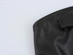 Close-up of black PU leather dress showing professional stitching and buckle detail