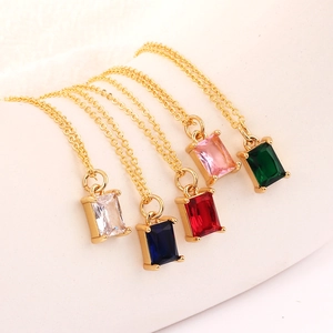 Gold necklaces featuring rectangular gemstone pendants in five colors on a beige display