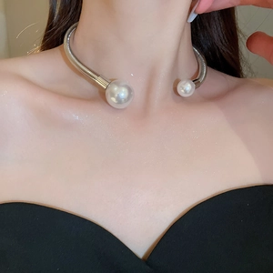 Detail of silver spring neck ring with large and small pearls on a fashion model