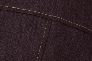 Gros plan détaillé des surpiqûres contrastées sur le tissu denim de l'ensemble femme