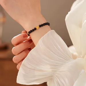 Sandalwood beaded bracelet with amber accent bead and gold spacers on a female wrist
