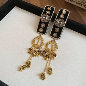 Macro view of vintage style velvet tassel earrings with golden bells and rhinestones