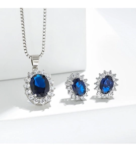 Close-up of Diana style sapphire necklace and earrings set with white zircon halo