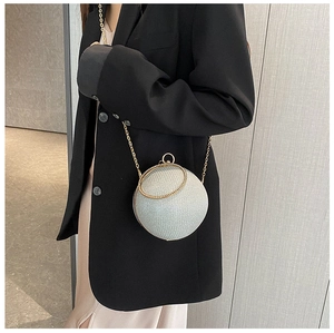 Detail einer kugelförmigen Abendtasche mit Silberglitzer und goldener Kette
