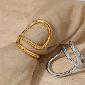 Minimalist irregular twisted gold and silver napkin rings with polished metallic finish