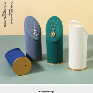 Detailed view of four velvet necklace display stands with premium gold metal trim bases