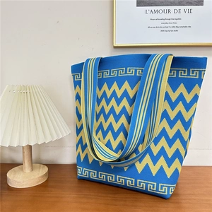 Close-up of blue and yellow wave pattern knit tote bag with Greek key borders