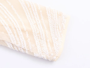 Detailed macro view of champagne mesh fabric with elegant white sequin stripe textures