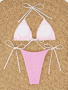 Detailed flat lay of bikini top with removable pads on a rustic woven beach mat
