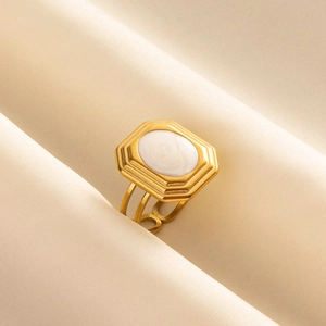 Detail of vintage 304 stainless steel gold ring with oval white enamel inlay
