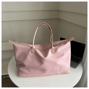 Close-up of pink waterproof oxford tote bag with leather handles on a white table
