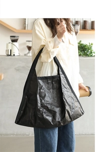 Detail of black pleated tote bag made of high-quality crinkled washed paper material
