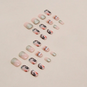 Short press-on nails with black leaf patterns and heart eye designs in glitter gradient