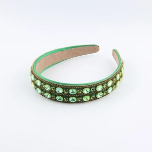 Baroque style green rhinestone headband with emerald crystals on satin base in 45-degree view