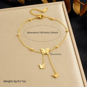 Detail showing gold butterfly bracelet with matte texture and 20cm chain on display