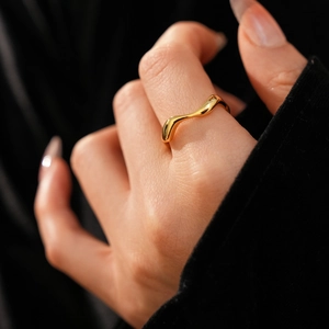 On-finger view of a minimalist 18k gold plated irregular wavy ring with modern design