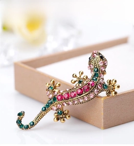 Macro shot of lizard brooch with colorful rhinestones on vintage bronze alloy base