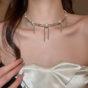 Macro detail of pearl choker with silver fringe tassels on a delicate collarbone chain