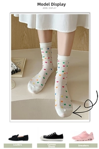 Detail of white mesh socks featuring colorful mini heart patterns and breathable knit fabric