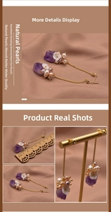 Detail view of long purple amethyst and natural pearl earrings with seashell floral accents