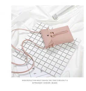 Detailed shot of pink pebble grain leather phone bag with gold ring buckle decoration