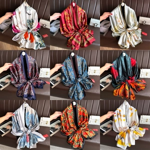 Detail view of nine elegant long silk scarves with various colors and smooth patterns