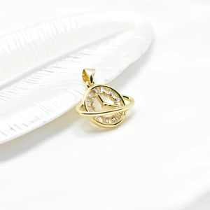 Gold planet clock pendant with white rectangular zircon markers on a ceramic leaf tray