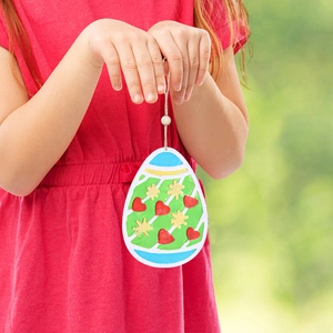 Close-up of colorful Easter egg pendant with heart and star patterns on a hanging rope
