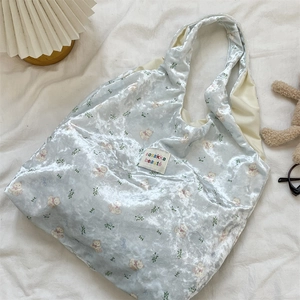 Detailed texture of light blue velvet tote bag with bear and floral patterns