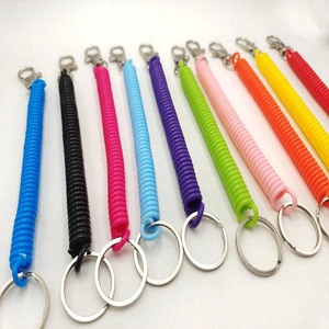 Detailed view of eleven colorful elastic spiral keychains with metal clips on white background