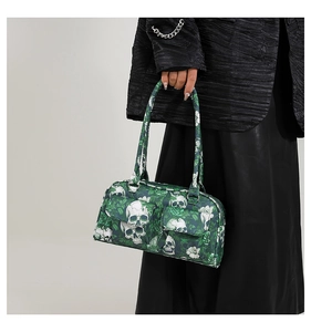 Detail of green skull and rose print handbag carried by a model in black outfit