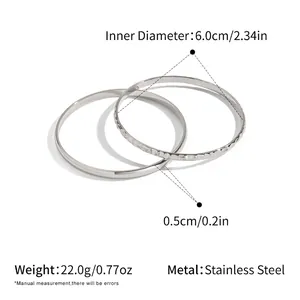 Dettagli dimensioni e texture martellata in oro 18K sul set di bracciali in acciaio