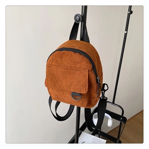 Close-up of brown corduroy backpack with front pocket and adjustable nylon straps