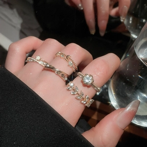 Detail of luxury gold ring set with flower, star and moon zircon crystals on model