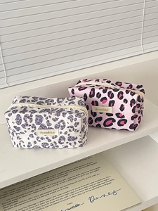 Vintage leopard print cosmetic bags with zippers on a white minimalist display stand